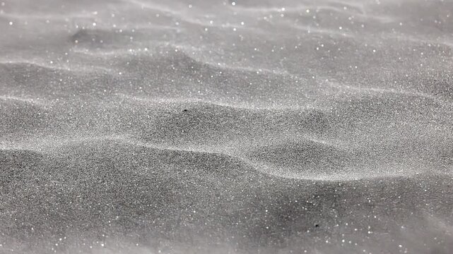 海風に飛ばされる湘南海岸の砂浜の砂粒