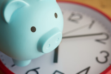 Blue piggy bank on clock background. Saving money, money management, financial planning for investment or retirement and so on concept.