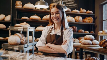 Smiling baker showcasing fresh bread in a cozy bakery  