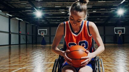 Young woman in wheelchair smiling while holding a basketball indoors   - Powered by Adobe