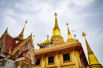 Fototapeta premium Wat Khiriwong, the highlight is the Ubosot and Phra Chulamani Chedi, located on the top of Khao Daowadueng, and offers a high angle view of Nakhon Sawan. It is a beautiful sunset viewing point.