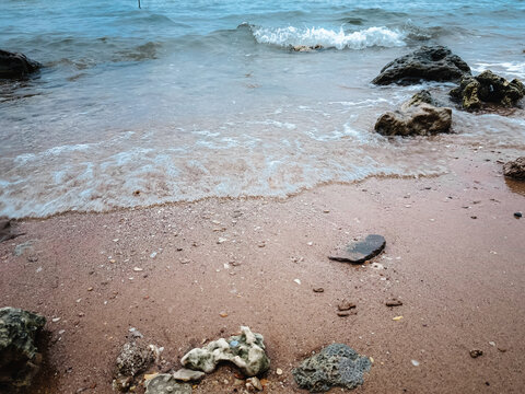 Tranquil Rocky Seaside with Overcast Sky and Gentle Waves