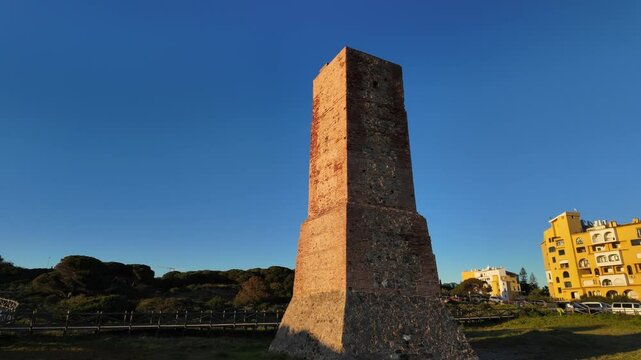 Scenic view of Torre Ladrones silhouetted against the setting sun on the Marbella coastline, Spain