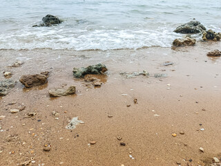 Tranquil Rocky Seaside with Overcast Sky and Gentle Waves