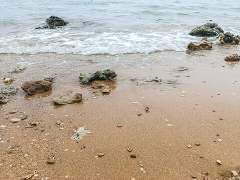 Tranquil Rocky Seaside with Overcast Sky and Gentle Waves