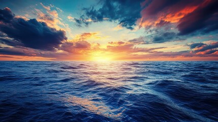 A deep sapphire blue ocean under a dramatic sunset sky