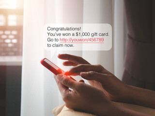 SMS scam, scams link from scammer for malware installing concept. Text messages, Winning congratulations phishing text with link tracking in speech bubble showing while woman use mobile phone at home.