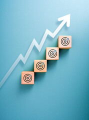 Business growth, goals and success planning concept. White zigzag arrow rising up on wood cube...