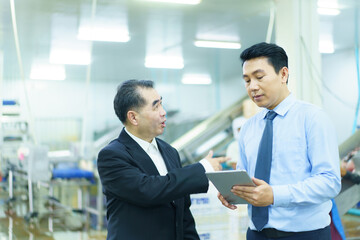 Engineer and manager are walking around the production line in factory.