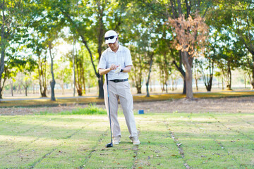 An Asian amateur golfer is enjoy playing golf in golf country club.