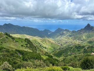Panoramic view of green Anaga mountains on blue ocean and sky background, sunny day in the North of Tenerife, Canary Islands, Spain 