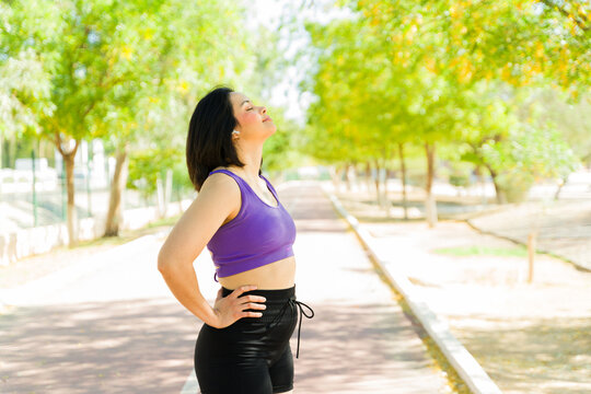 Runner taking deep breath while resting after workout in park