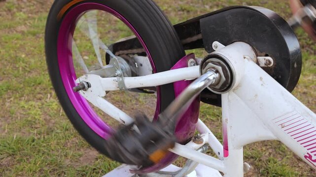Focused on adjusting and fixing a bicycle wheel, showcasing the crucial steps and tools used in the repair process outside