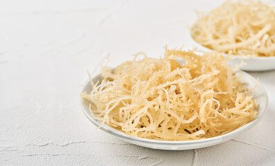 closeup pile of white eucheuma cottonii kelp seaweed in bowl on white table food background with copy space