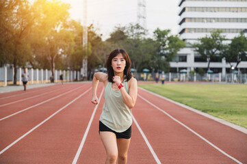focused southeast Asian woman runner on track during sunset, embodying healthy lifestyle and wellness. Her determined expression reflects motivation and challenge of fitness
