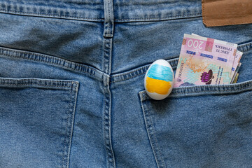 Easter egg with a picture of the flag of Ukraine and two hundred hryvnia lie in the pocket of...