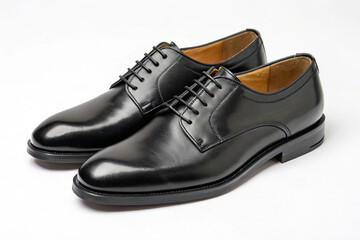 A pair of elegant shiny black leather dress shoes with black laces are presented on a stark white background, representing formal men's footwear.