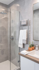 modern gray tiled bathroom with glass shower enclosure and heated towel rack