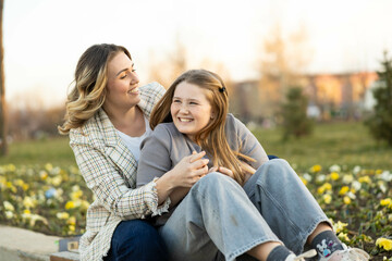 Naklejka premium A heartwarming scene of mother and daughter sharing laughter and joy in a sunny park setting, embodying friendship and happiness.