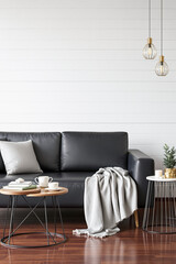 modern living room with black leather sofa and gray throw