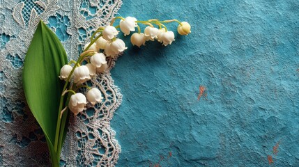 Beautiful Lily of the Valley Flowers on Lace Against a Textured Blue Background