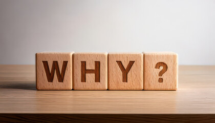 Wooden blocks spelling WHY on light table background