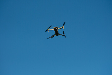 Flying Drone in Clear Blue Sky – Front View of Quadrocopter in Flight