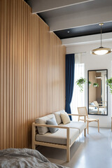 bright and airy modern living room with light wood slat wall and neutral sofa