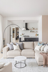 beige sectional sofa in a modern open-plan living room with stylish kitchen
