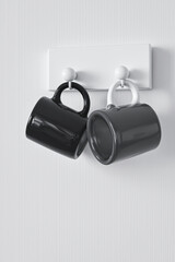 two coffee mugs hanging on a white rack