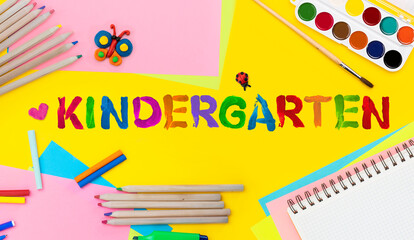 Kindergarten background. Top view flat lay concept. Childish lettering, colored paper, supplies, stationery for Pre-school, nursery school, kindergarten or preschool educational