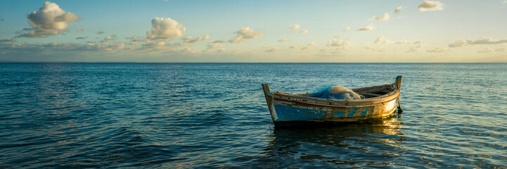 Obraz premium Serene Seascape Featuring Small Fishing Boat Floating On Calm Ocean Water