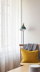 wooden chair with yellow cushion and black and white throw near sheer curtains