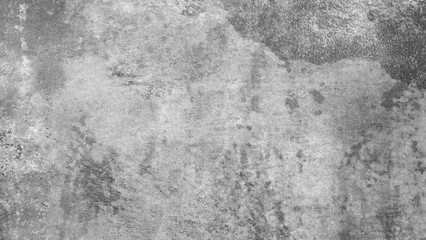 Gray rough textured abstract background.  A grey wall with a few stains and cracks. The wall is made of concrete and has a rough texture