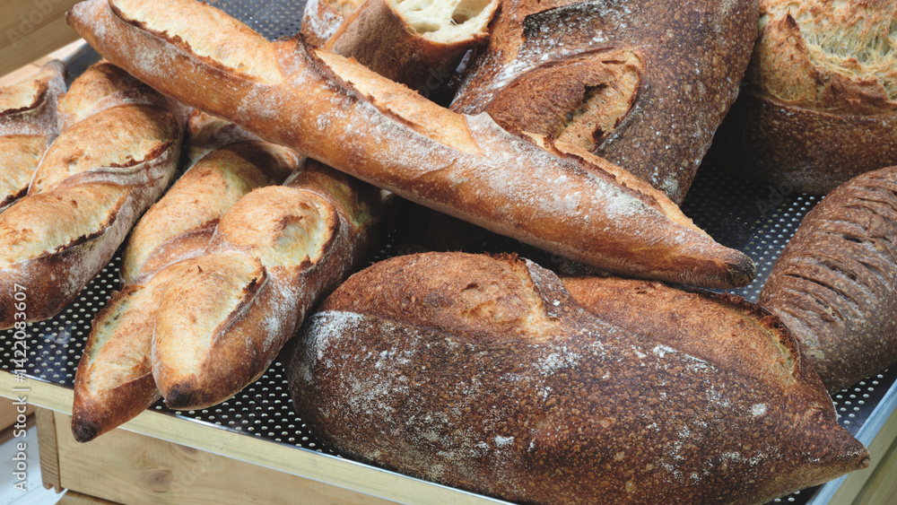 Poster A display of bread with a variety of shapes and sizes. The bread is arranged on shelves and is ready to be sold