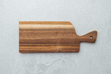 Wooden cutting board on gray countertop ready for food preparation