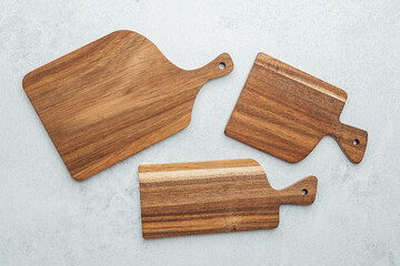 Wooden cutting boards arranged on a light gray surface in a kitchen setting