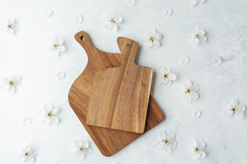 Wooden cutting boards arranged with delicate white flowers on a light background