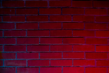 Red brick wall illuminated with blue and pink neon lights creating a vibrant and textured background.