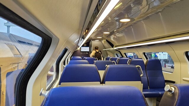 Interior of NS (Nederlandse Spoorwegen) Intercity train seats. Second class ticket with comfortable, blue chairs, seating area.