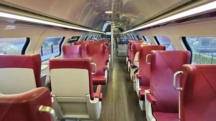 Interior of Dutch Intercity train business seats. First class ticket with comfortable, luxury red chairs.