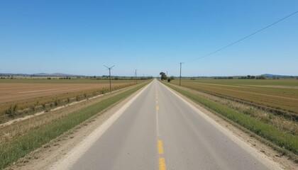 Fototapeta premium Open Road Stretching Through Scenic Rural Landscape Under Clear Sky