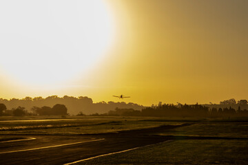 Ultralight agricultural plane taking off at sunset over Tatui, Brazil