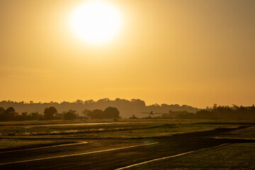 Ultralight agricultural plane taking off at sunset over Tatui, Brazil