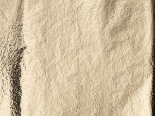 Golden foil texture with a crinkled, metallic surface. Elegant, smooth pattern with warm light and subtle shimmer for a luxury, vintage backdrop. Polished, premium wrapping material with a refined,.