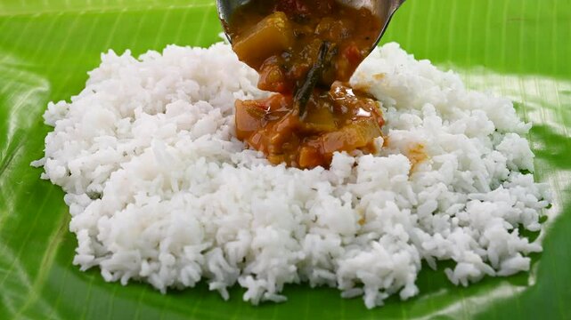 Serving spicy sambar on white rice. Sambar rice is a popular south indian meal.