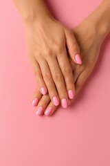 Fototapeta premium Female hands with pink nail design. Female hands on pink background. A Guide to Beautiful Nails. Manicure and Hands Spa. Manicured nails and Soft hands skin on pink background. Female manicure.