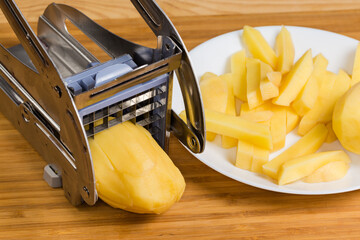 Manual slicer for French fries during potato slicing, close-up