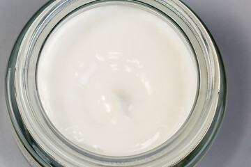White cosmetic cream in open jar, top view close-up