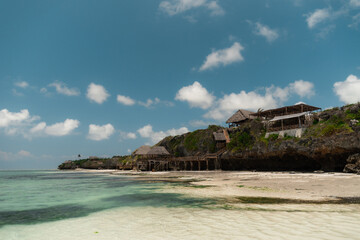 Wooden beach huts overlooking the turquoise ocean in zanzibar, tanzania